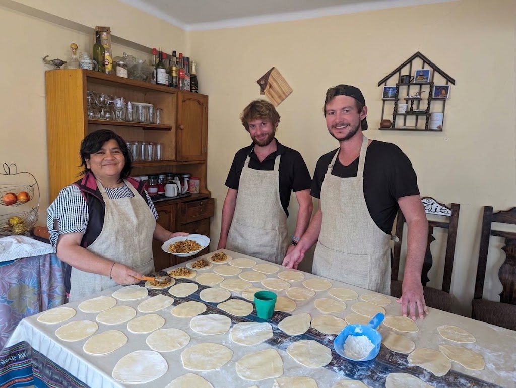 Doña Marlene y estudiantes compartiendo y rellenando empanadas caseras en la cocina